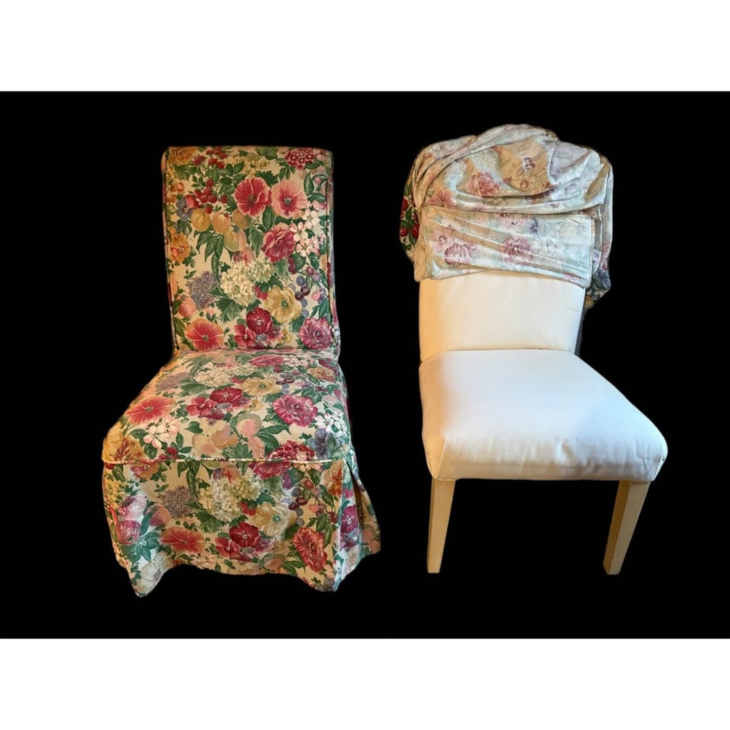 Pair of white upholstered chairs with floral covers over them