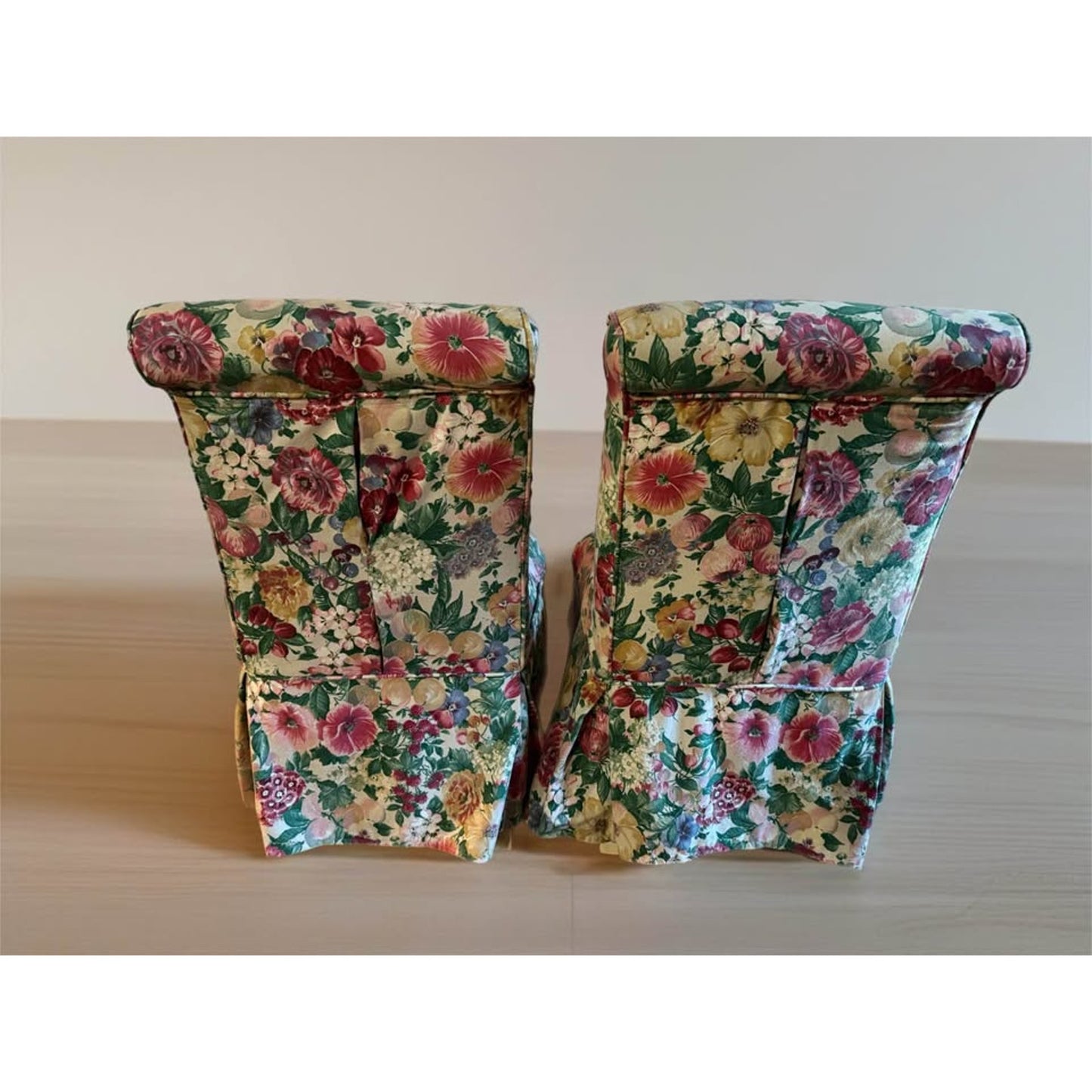 Pair of white upholstered chairs with floral covers over them